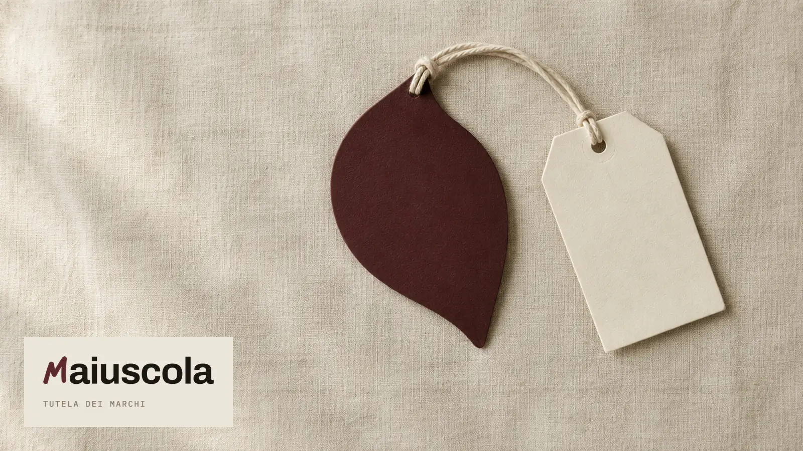 Una foglia di carta rosso scuro legata a un cartellino bianco senza scritte: copertina della guida sul marchio figurativo o denominativo